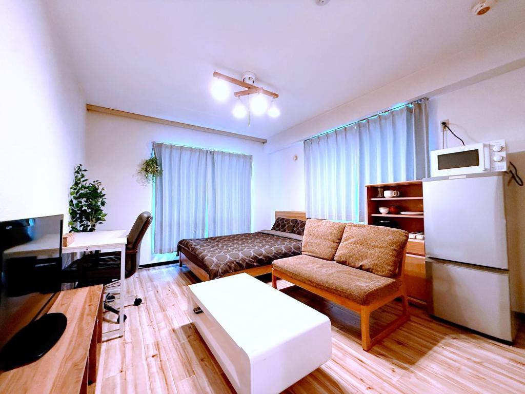 ein Wohnzimmer mit Couch und Kühlschrank in der Unterkunft ParkResidence -FIX HOME- in Sapporo