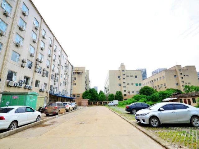 a group of cars parked in a parking lot at Jinjiang Inn Wuhan Optics Valley Avenue GaoXinEr Road in Wuhan