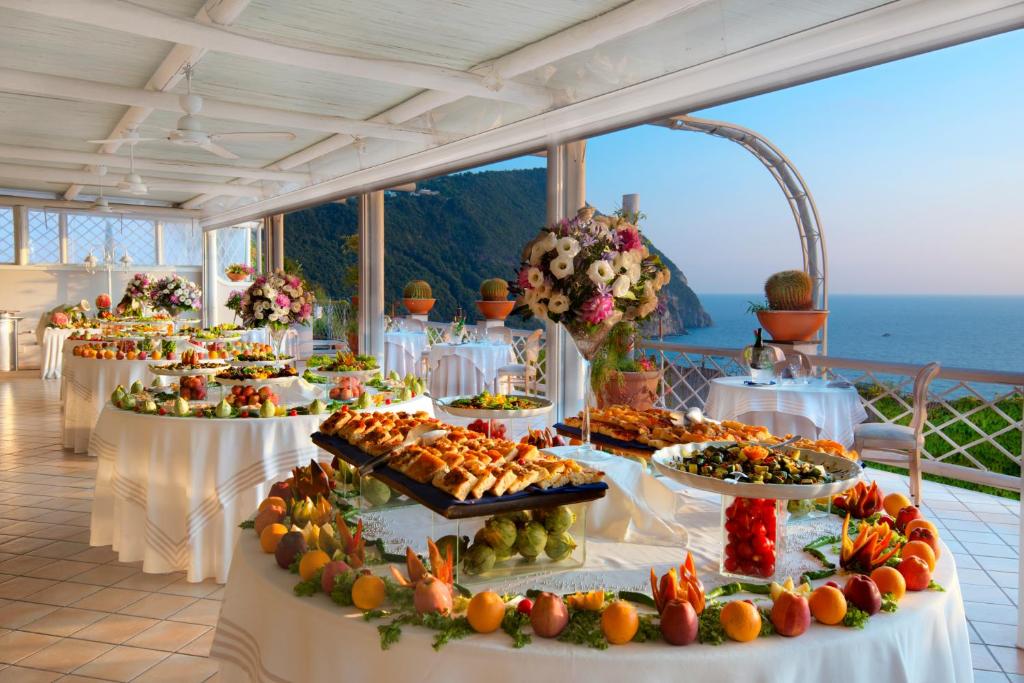a buffet line of food on tables with the ocean in the background at Sorriso Thermae Resort & Spa in Ischia