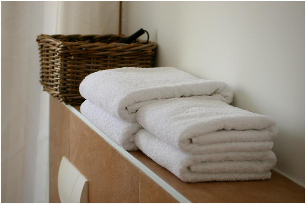 a pile of towels sitting on a shelf in a bathroom at Apartments Ercegovic in Primošten