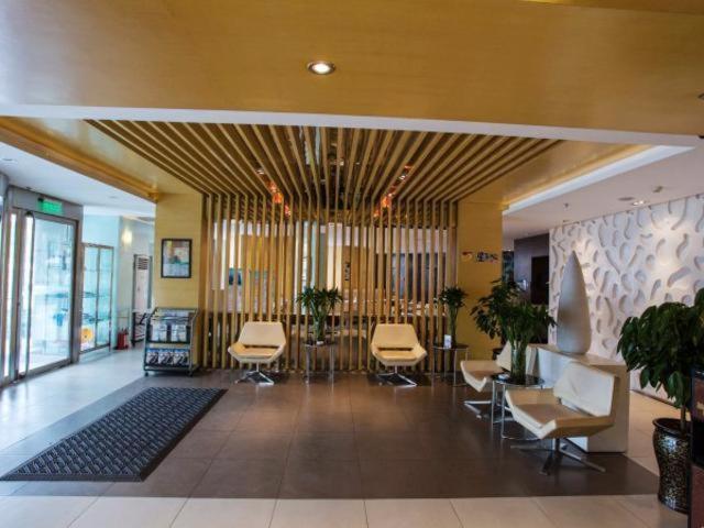 a lobby with chairs and tables in a building at Jinjiang Inn Jinzhou Luoyang Road in Jinzhou