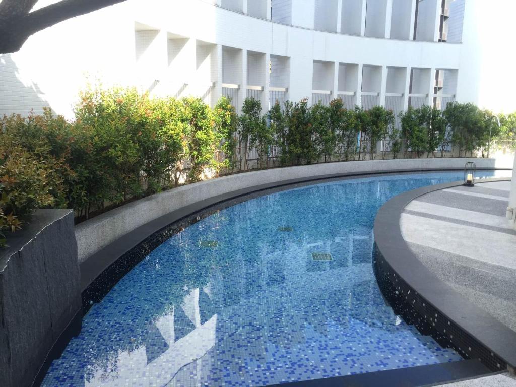 a swimming pool in front of a building at All-Ur Boutique Motel - Xinzhuang Branch in Xinzhuang