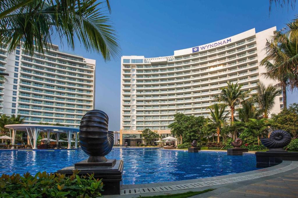 a hotel with a pool in front of a building at Wyndham Sanya Bay in Sanya