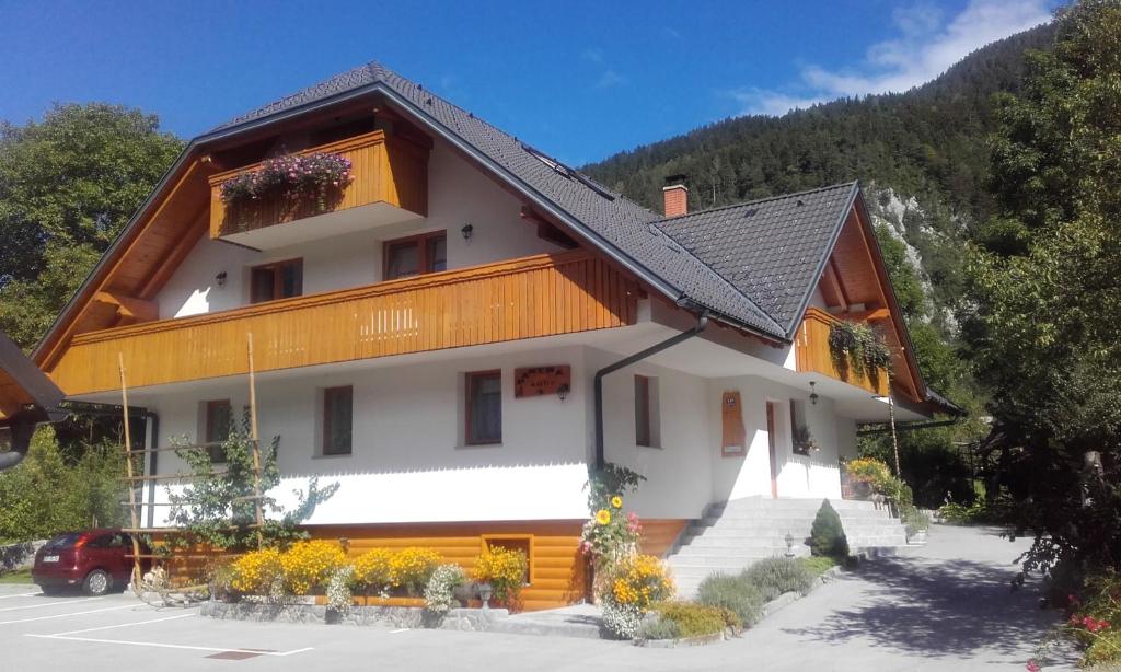 a large white building with a black roof at Apartments and Rooms Martuljk in Kranjska Gora