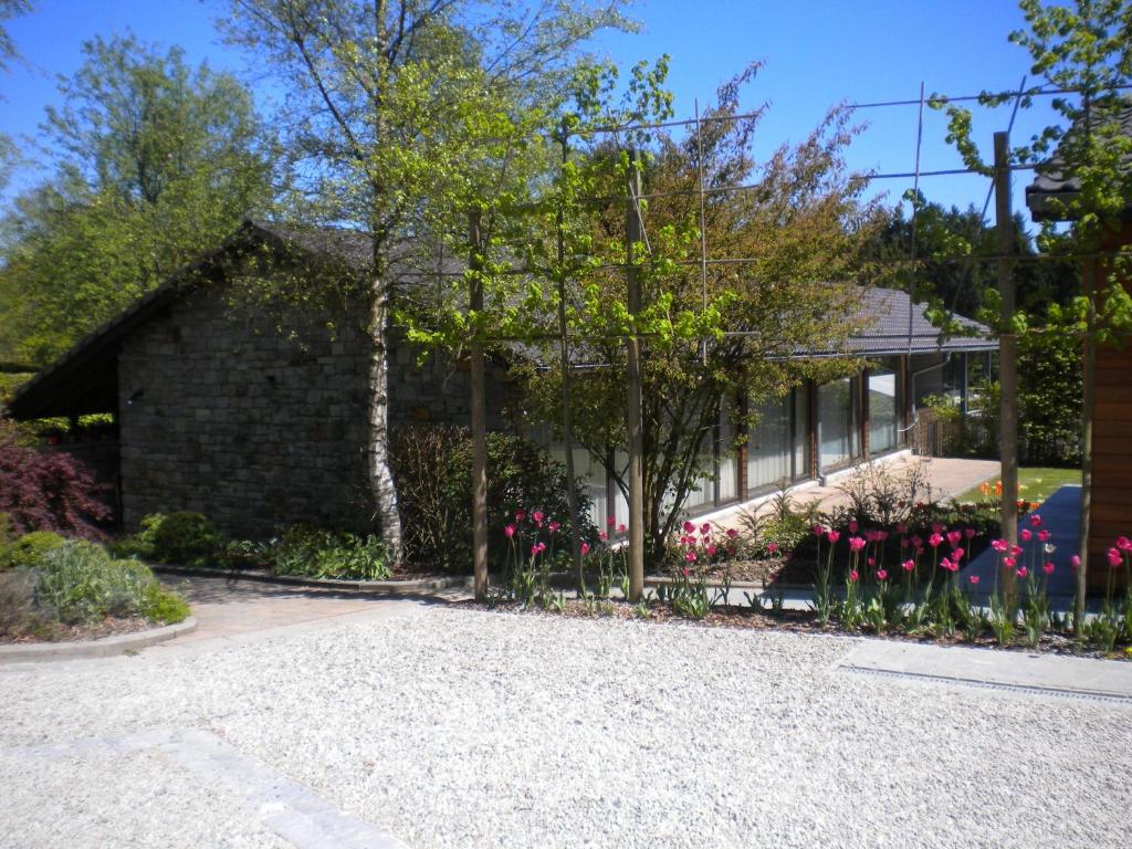 una casa con flores rosas en la entrada en B&B La Romance du Lac en Robertville