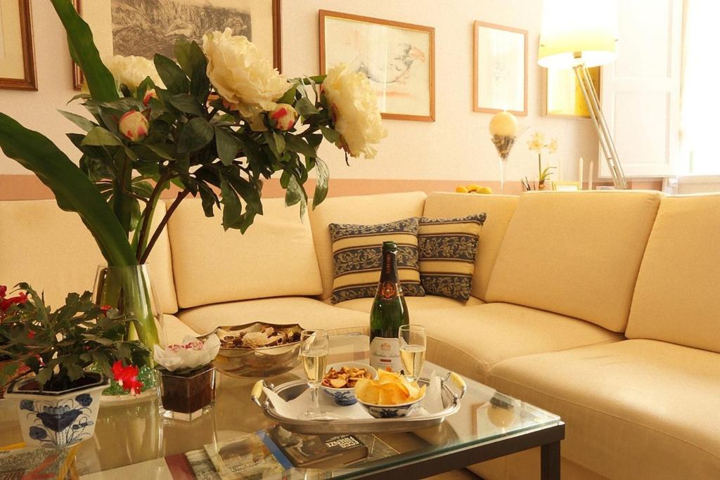 soggiorno con divano e tavolo con bottiglia di champagne di Badia Fiorentina a Firenze