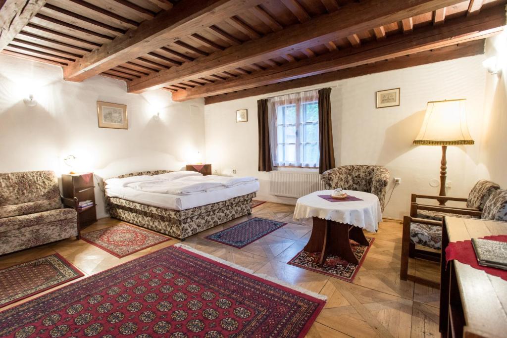 1 dormitorio con 1 cama, mesa y sillas en Pension Dientzenhofer, en Praga