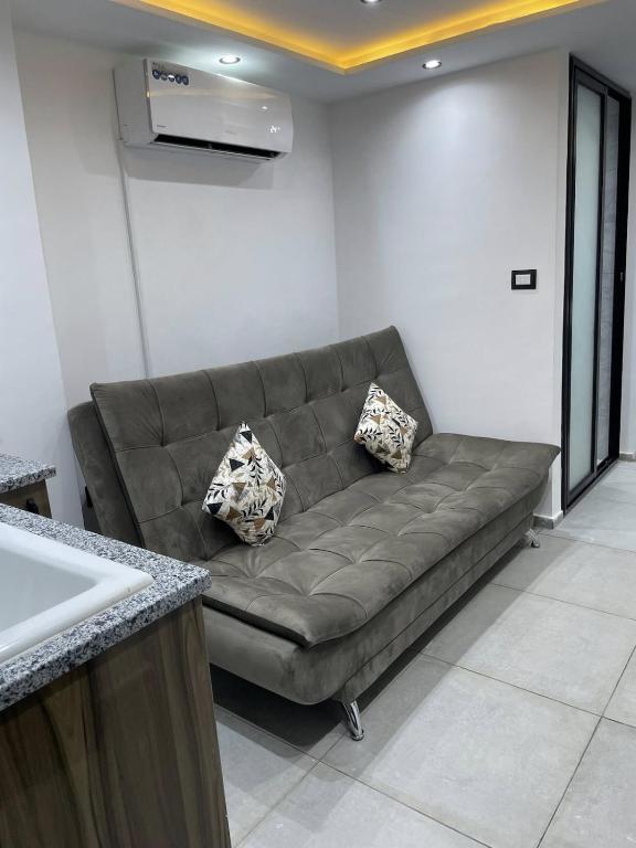 a brown couch in a room with a kitchen at Studio Chic in Mahdia