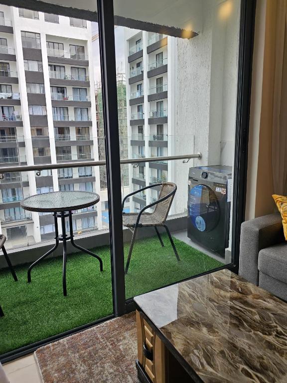 a room with a balcony with a table and a couch at Comfy Bnb in Syokimau