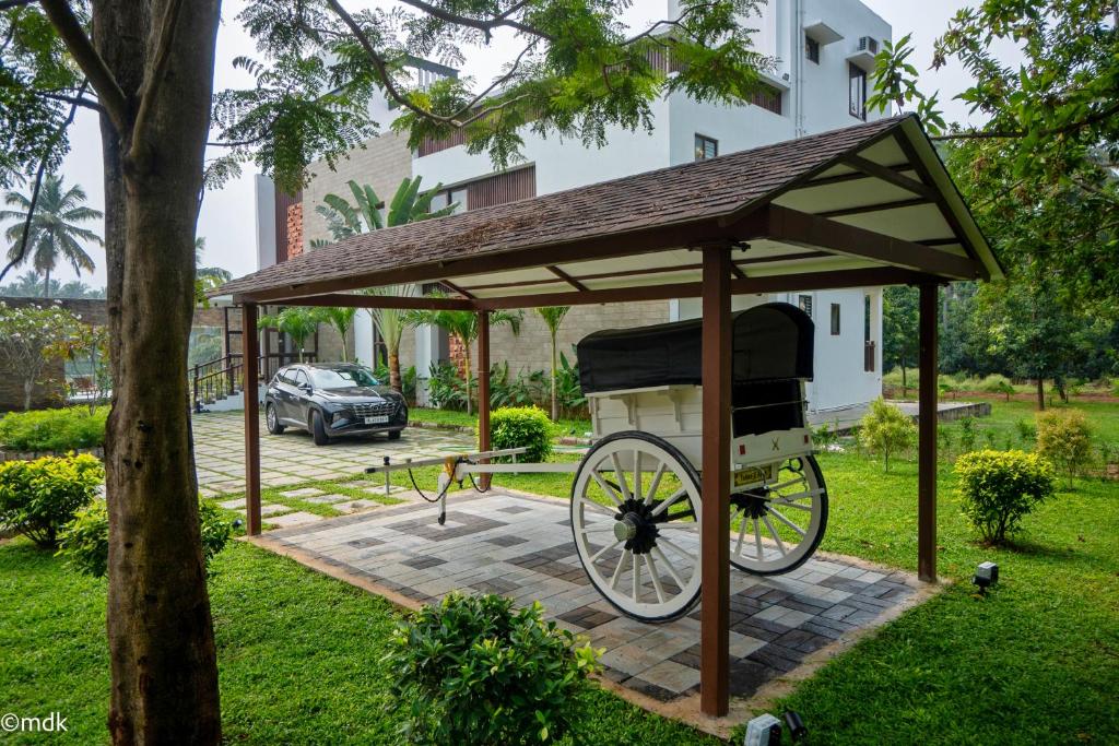 Un cenador con un asador de pollos en un parque en Pollachi Riverhouse, A CGH Earth Saha experience, en Pollachi