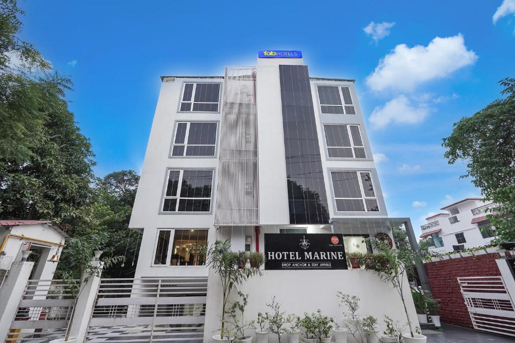 a white building with a sign in front of it at FabHotel Marine - Vishnu Temple Bada Lalpur in Varanasi