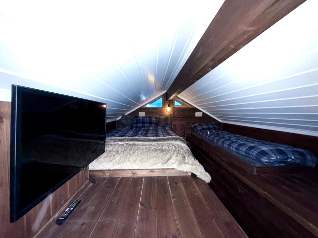 a room with a bed and a flat screen tv at Utibakken - cabin ski inn-out Norefjell in Surteberg