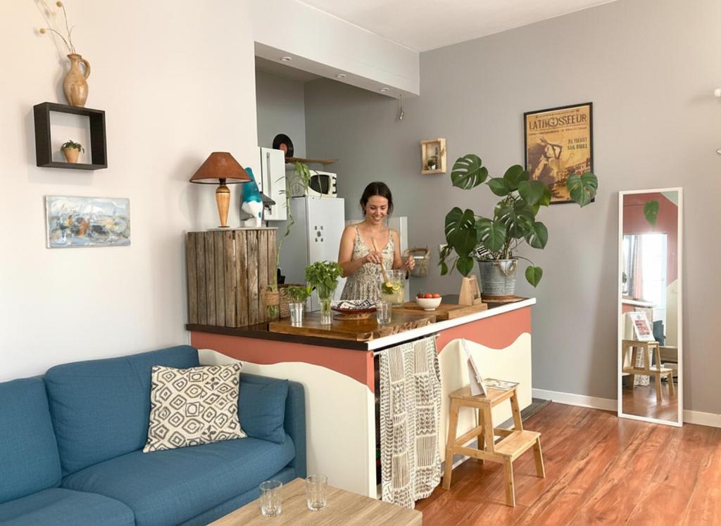 a woman standing at a bar in a living room at Chez Jigé - Bel appartement à côté de l'Adour in Bayonne