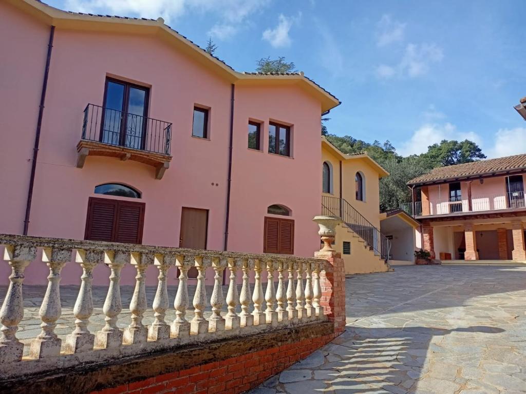 a pink house with a white fence at Il Borgo in Iglesias