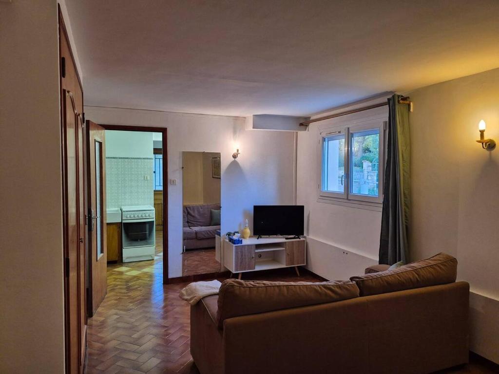 ein Wohnzimmer mit Sofa und Fernseher in der Unterkunft Charmant studio centre village in Gréoux-les-Bains