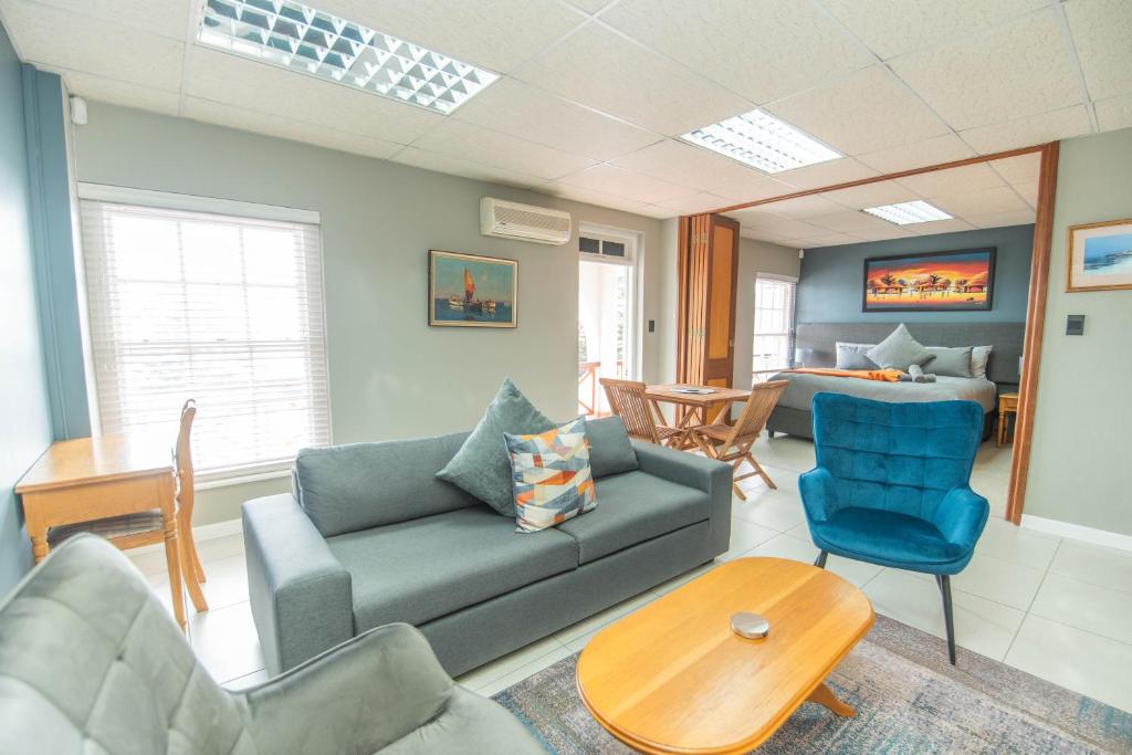 een woonkamer met een bank, stoelen en een tafel bij Cyprus Seas in Gqeberha