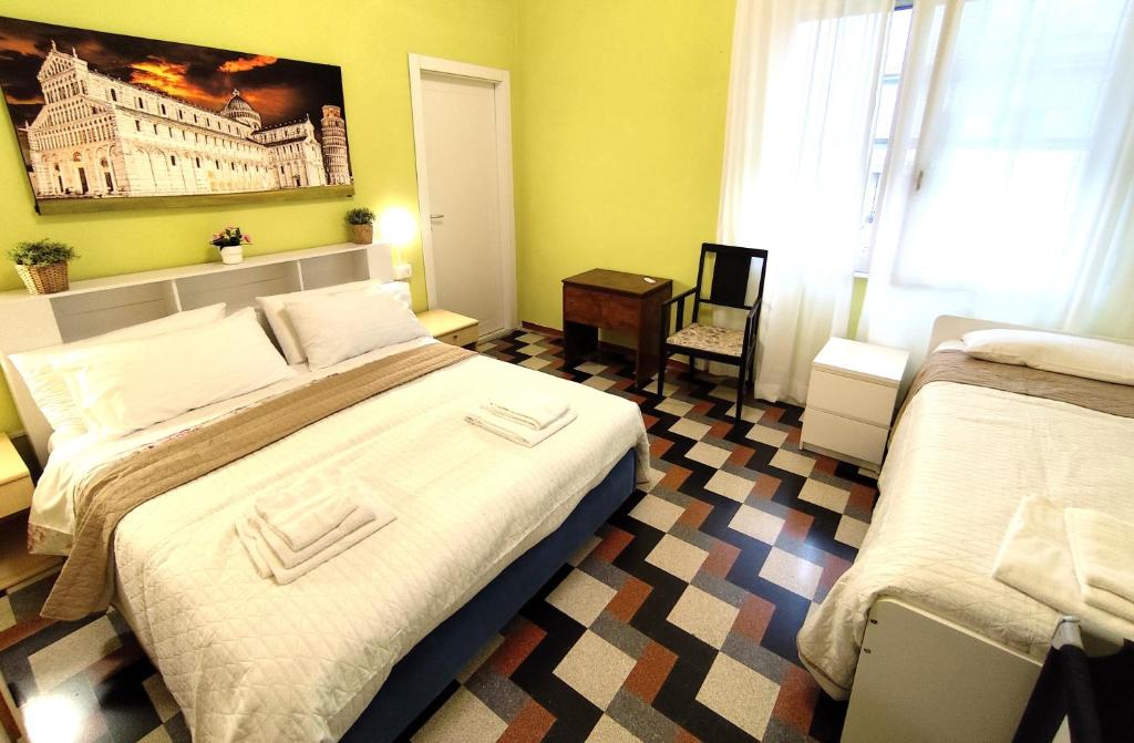 - une chambre avec 2 lits et une photo d'un bâtiment dans l'établissement Villa Mehari, à Pise