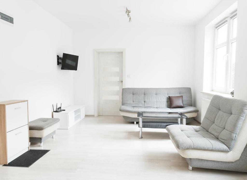 a living room with two chairs and a couch at Sunny Stay by Grafit in Legnica