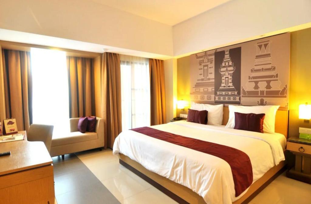 a hotel room with a large bed and a chair at Hotel Radhe in New Delhi