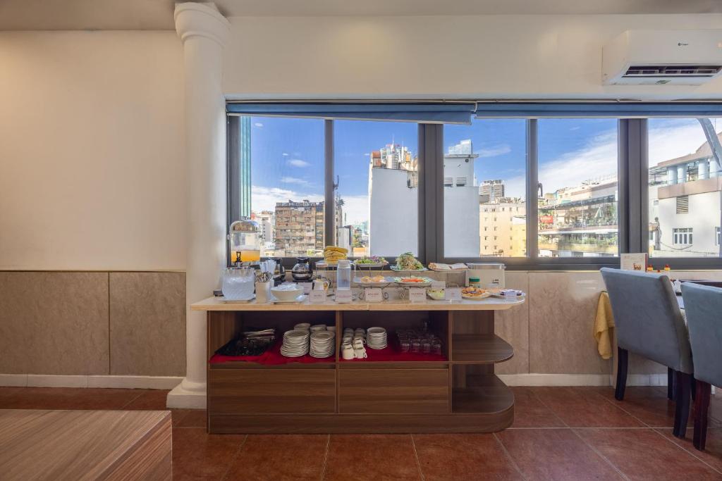 a restaurant with a view of a city from a window at A25 Hotel - 35 Mạc Thị Bưởi in Ho Chi Minh City