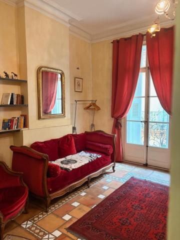 a living room with a red couch and a window at Bartissol et Maillol in Perpignan
