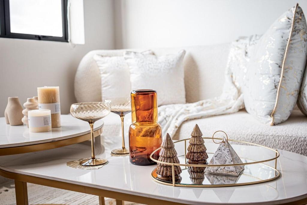 a white living room with a coffee table with a glass vase at The Nest in Midrand