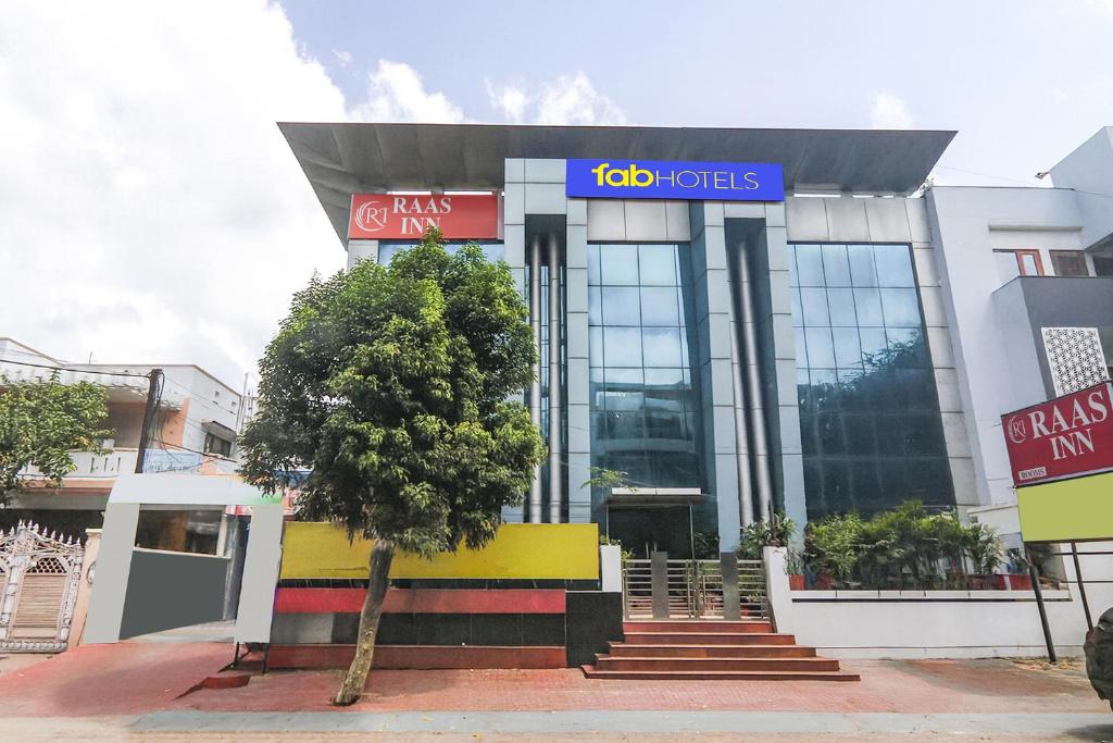 a building with a tree in front of it at FabHotel Raas Inn in Lucknow