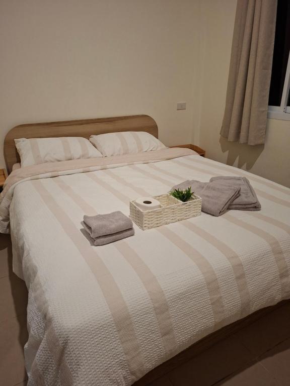 a bed with two towels and a basket on it at Houses in Ban Nua