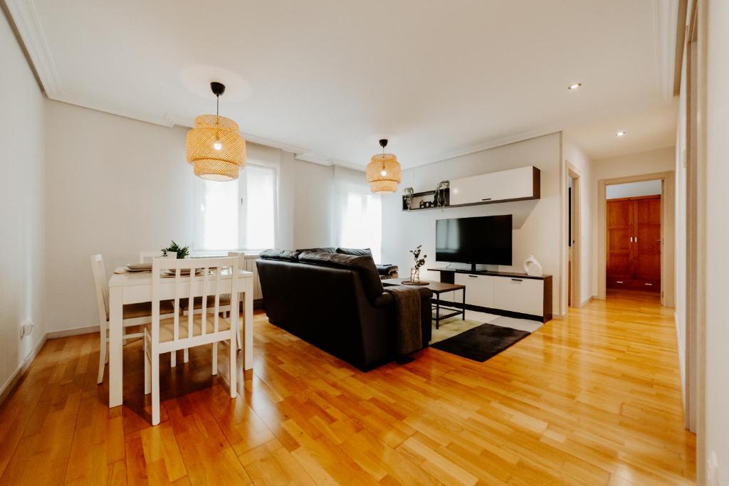 ein Wohnzimmer mit einer schwarzen Couch und einem Tisch in der Unterkunft Living Logroño in Logroño