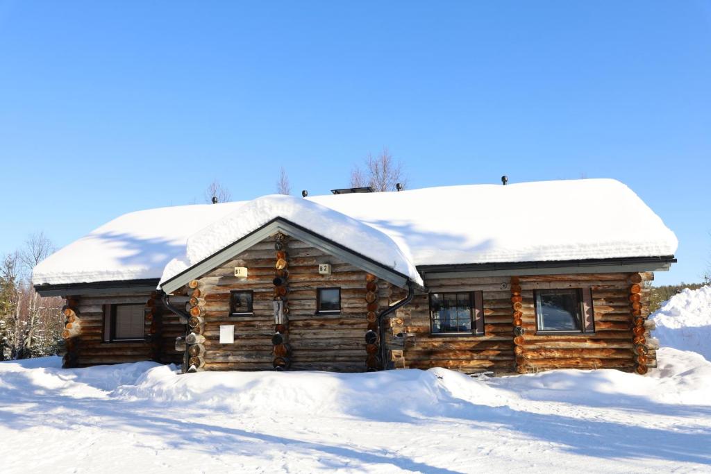 eine Blockhütte mit Schnee auf dem Dach in der Unterkunft Holiday Home Kantapää B1 in Luosto