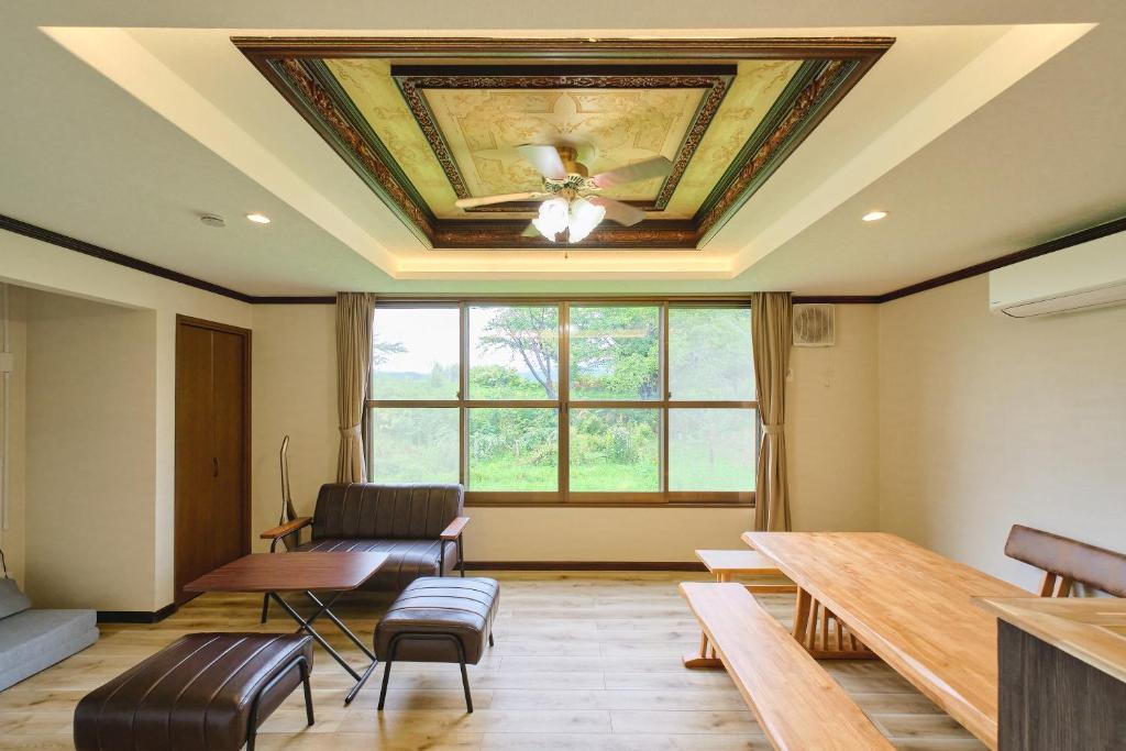 a room with a coffered ceiling with a table and chairs at テントサウナがある家 余市町 in Kurokawamachi