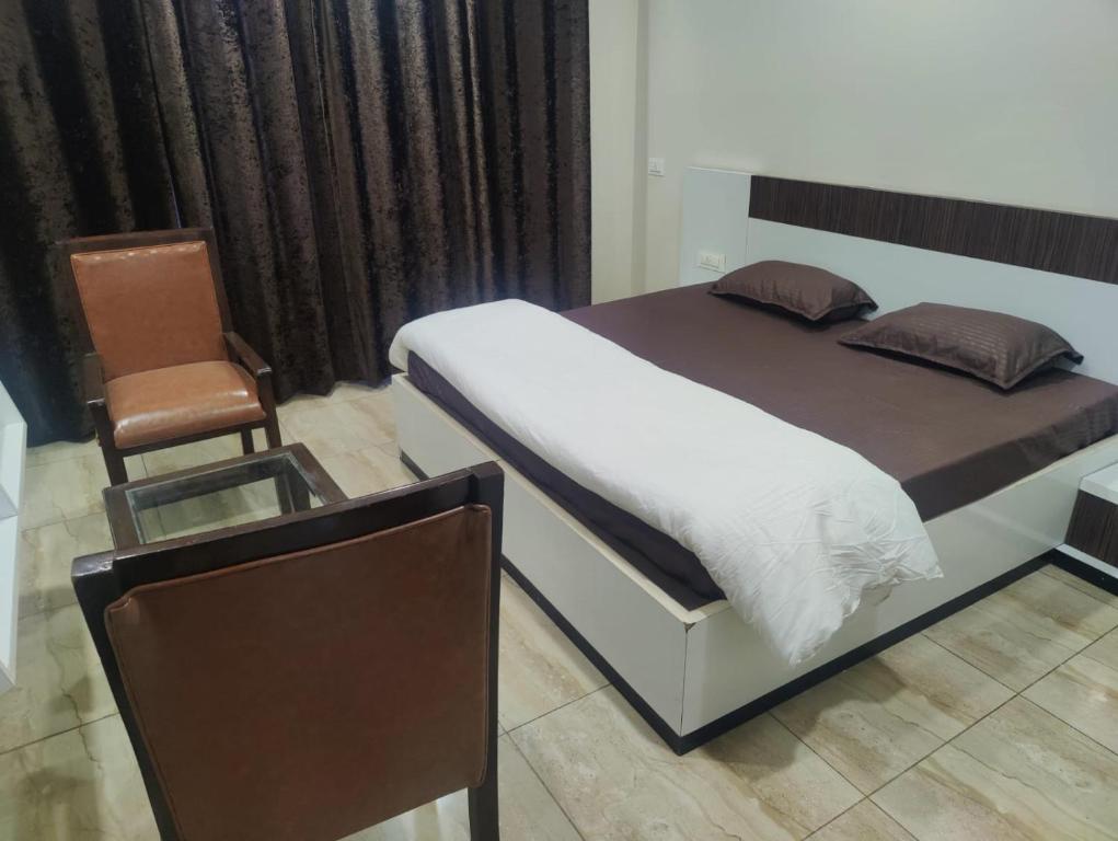 ein Schlafzimmer mit einem Bett und einem Stuhl in der Unterkunft Shukla Bhawan in Panchkula