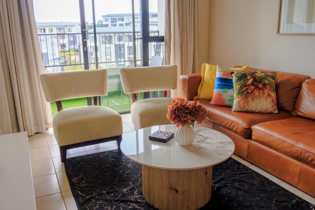 a living room with a couch and a table at Charming 2 Bedroom apartment in Ballito