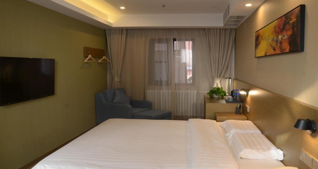 une chambre d'hôtel avec un lit et une chaise dans l'établissement Beijing Northern Langyue Hotel Financial Street Branch, à Pékin