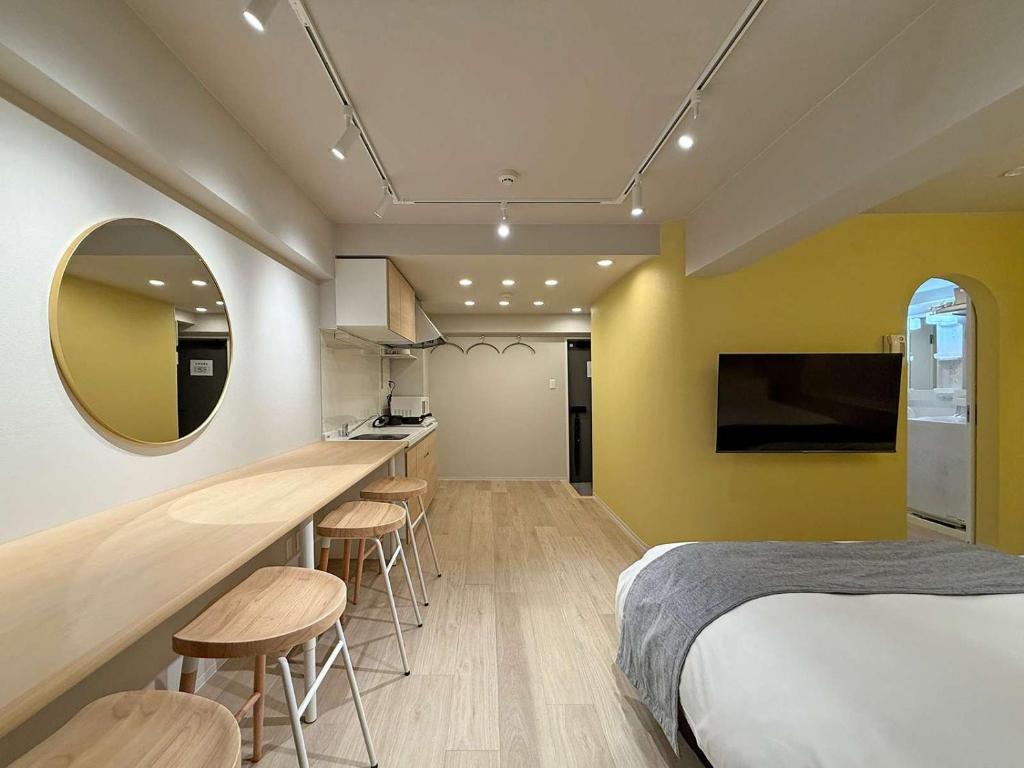 - une chambre avec un lit et un bar avec des tabourets dans l'établissement Clio Matoba by b hotel - Fully Equipped Urban Studio Peaceful Stay, à Ōsukachō