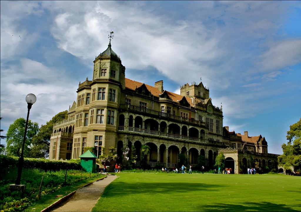 a large building with a green lawn in front of it at Lords Grey near Mall Road in Shimla