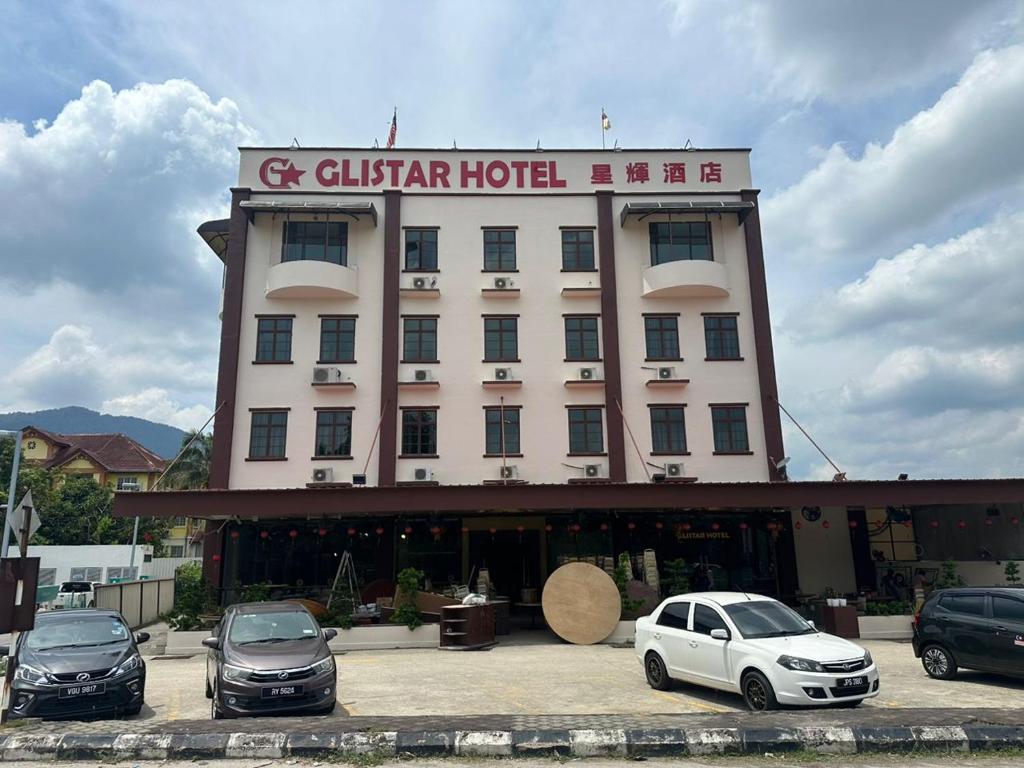 Un edificio con coches aparcados delante. en Glistar Hotel, en Tampin