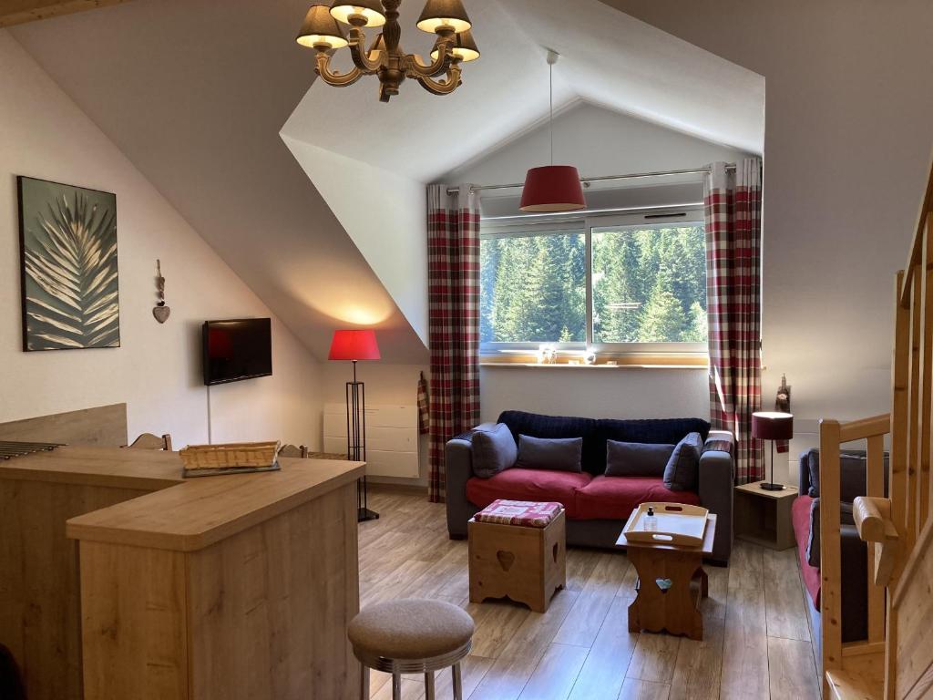 a living room with a couch and a window at T2 avec vue sur les montagnes et wifi in Le Lioran