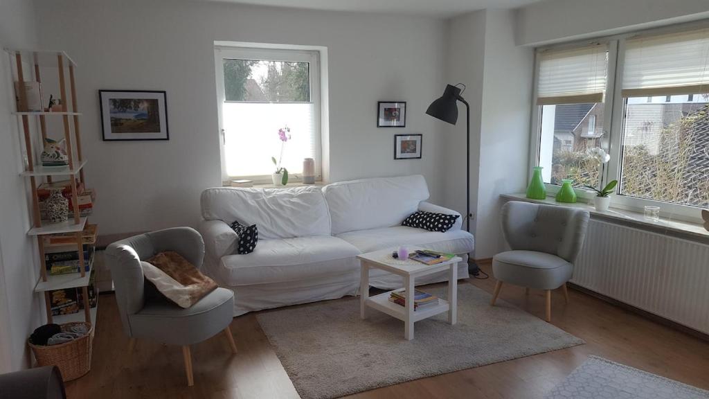 sala de estar con sofá blanco y 2 sillas en Ferienwohnung Hunteblick, en Wildeshausen