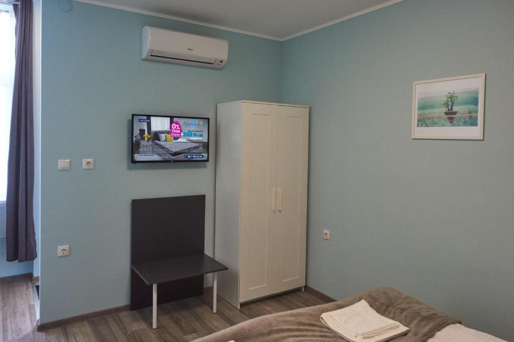a living room with a tv on the wall at Margaréta Studió Apartman in Pusztavacs
