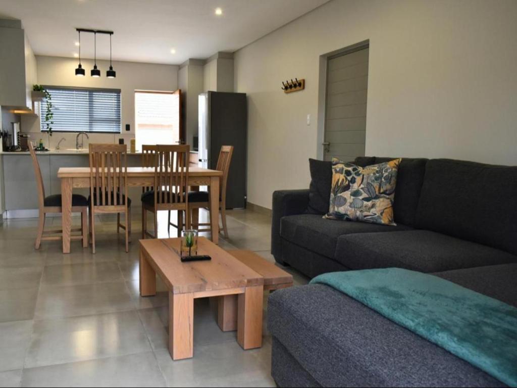 ein Wohnzimmer mit Sofa und Tisch in der Unterkunft 1 on York Townhouse 3 in George