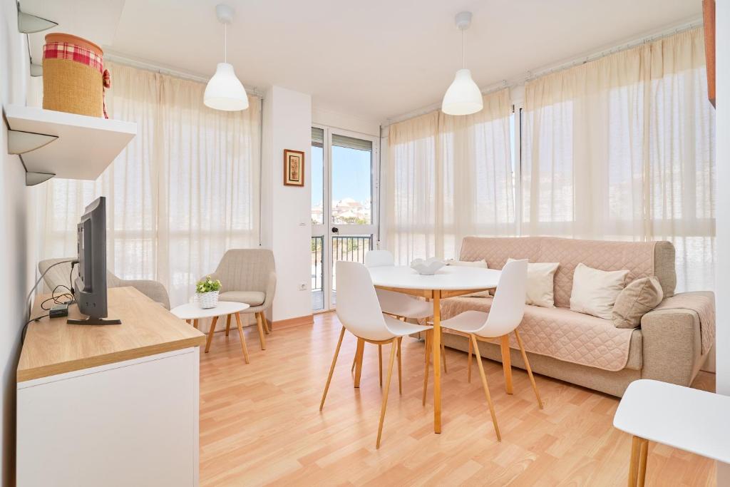 ein Wohnzimmer mit Sofa und Tisch in der Unterkunft Apartamento Con Parking Y Piscina in Castillo Bajo