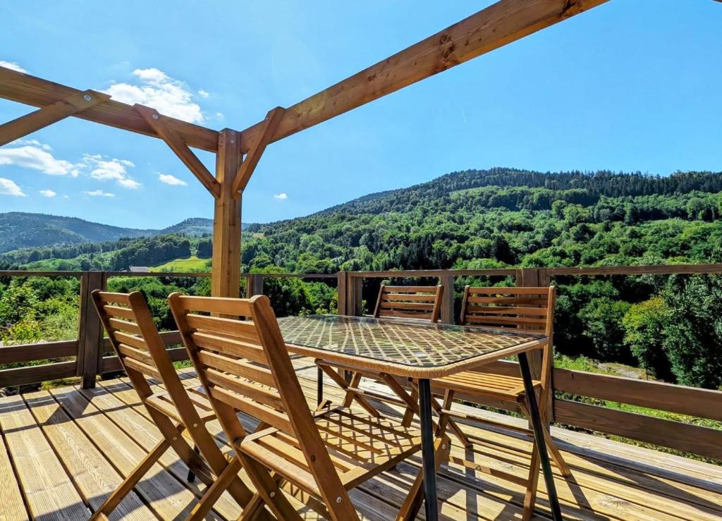 een tafel en stoelen op een terras met uitzicht bij Chtite Vosgienne Gîte 4 étoiles cosy in Vecoux