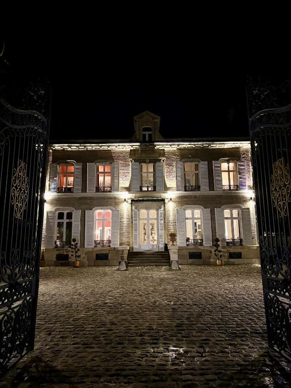 a large white building with lights on it at night at La Léontine in Abbeville