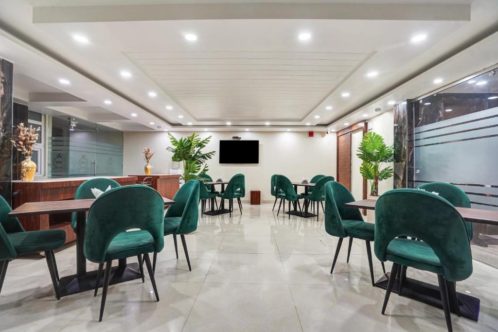 a waiting room with green chairs and tables at Hotel Royal Rosette with free Wi-Fi Near New Delhi Railway Station and Connaught Place in New Delhi