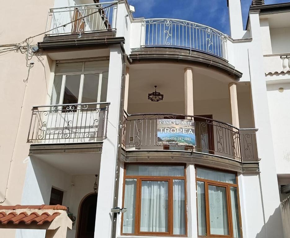 ein weißes Gebäude mit Balkonen an der Seite in der Unterkunft Casa Vacanze Tropea in Santa Domenica