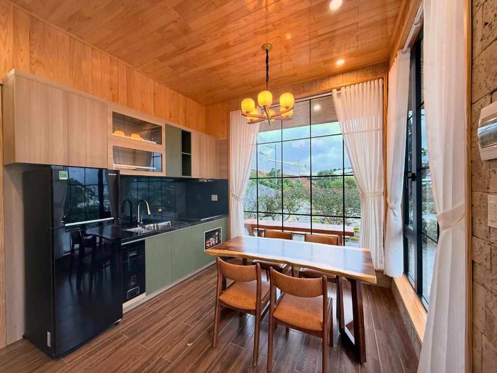 a kitchen with a table and chairs and a window at Kem Rose Trại Mát in Trai Mat
