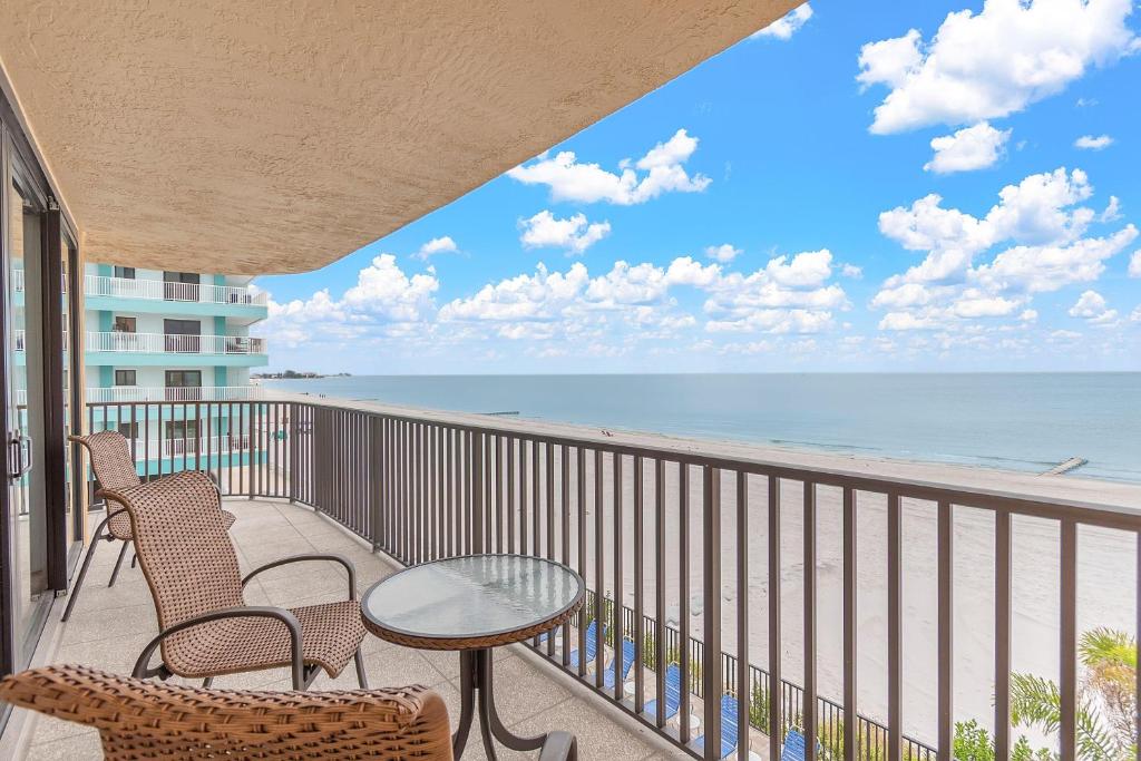 a balcony with a table and chairs and the beach at Trillium 2A - Premier in St. Pete Beach