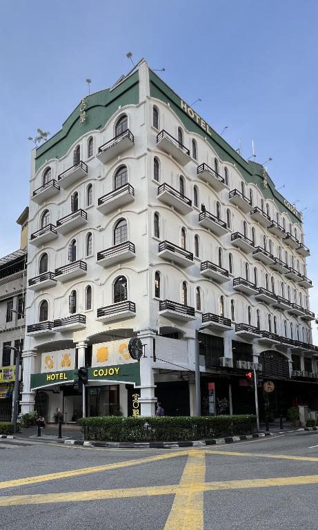 a large white building on the corner of a street at Cojoy Hotel @ Chinatown in Kuala Lumpur