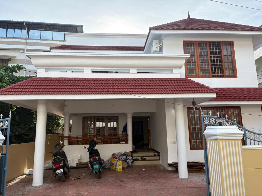 zwei Motorräder, die vor einem Gebäude geparkt sind in der Unterkunft Texas 3 BHK villa for 13 pax near Airport in Thiruvananthapuram
